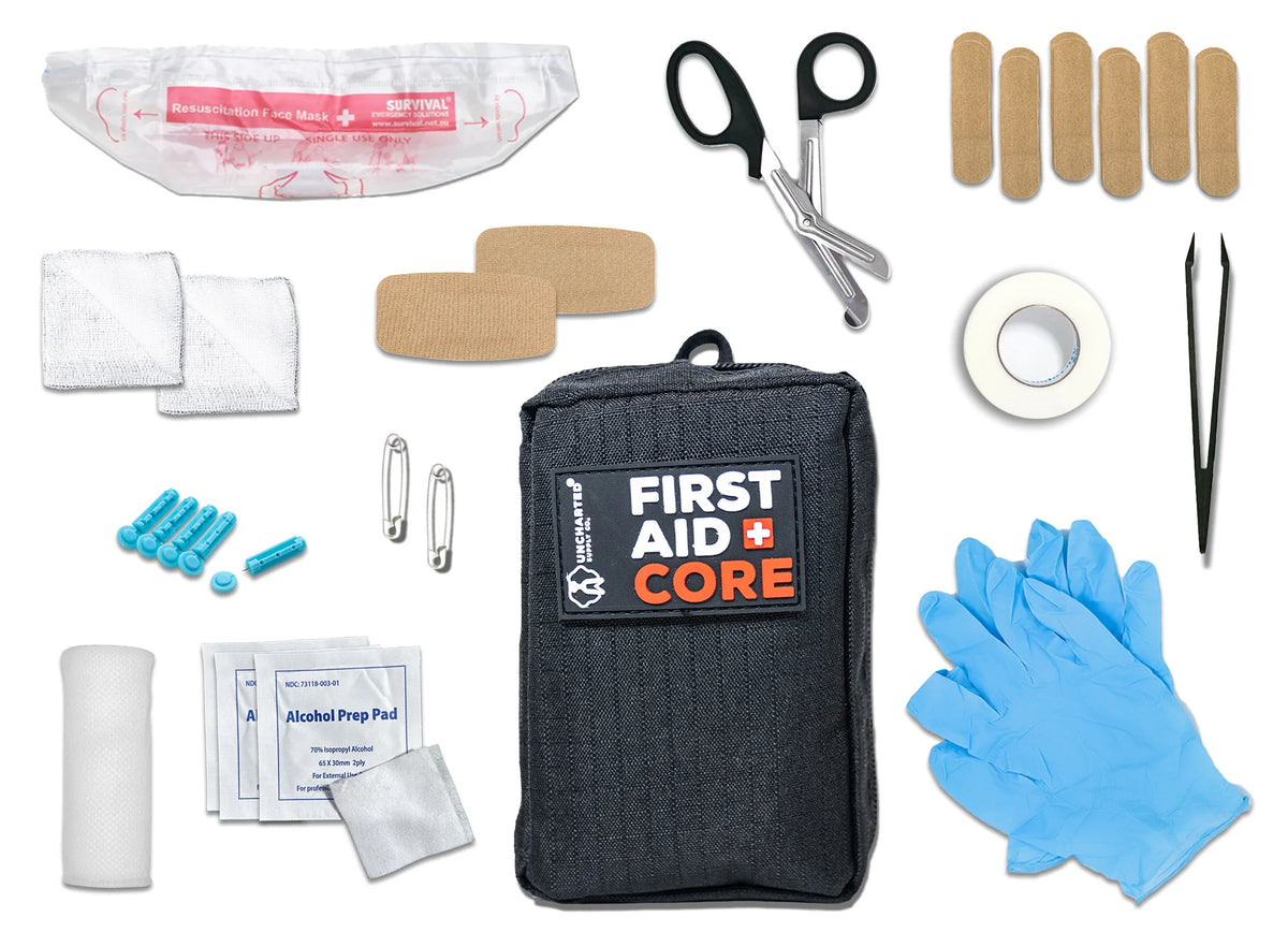 First aid kit core components for outdoor survival and emergency preparedness displayed on a tactical layout.