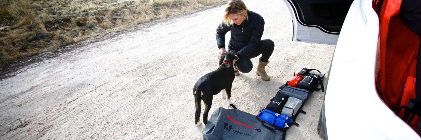 Uncharted Survival Systems gear display showcasing emergency preparedness equipment in an outdoor setting.